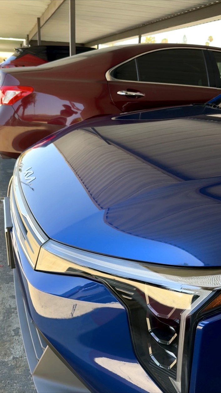 Deep gloss blue sedan hood after paint correction and ceramic sealant