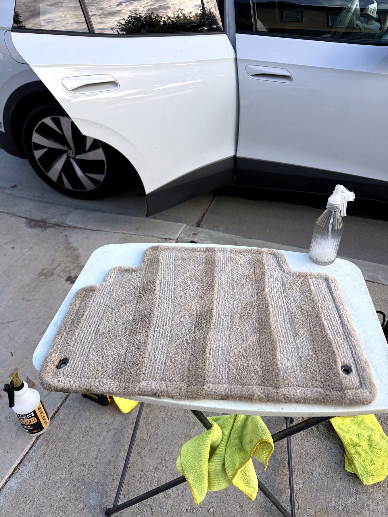 Car floor mat being deep cleaned during a mobile interior detail